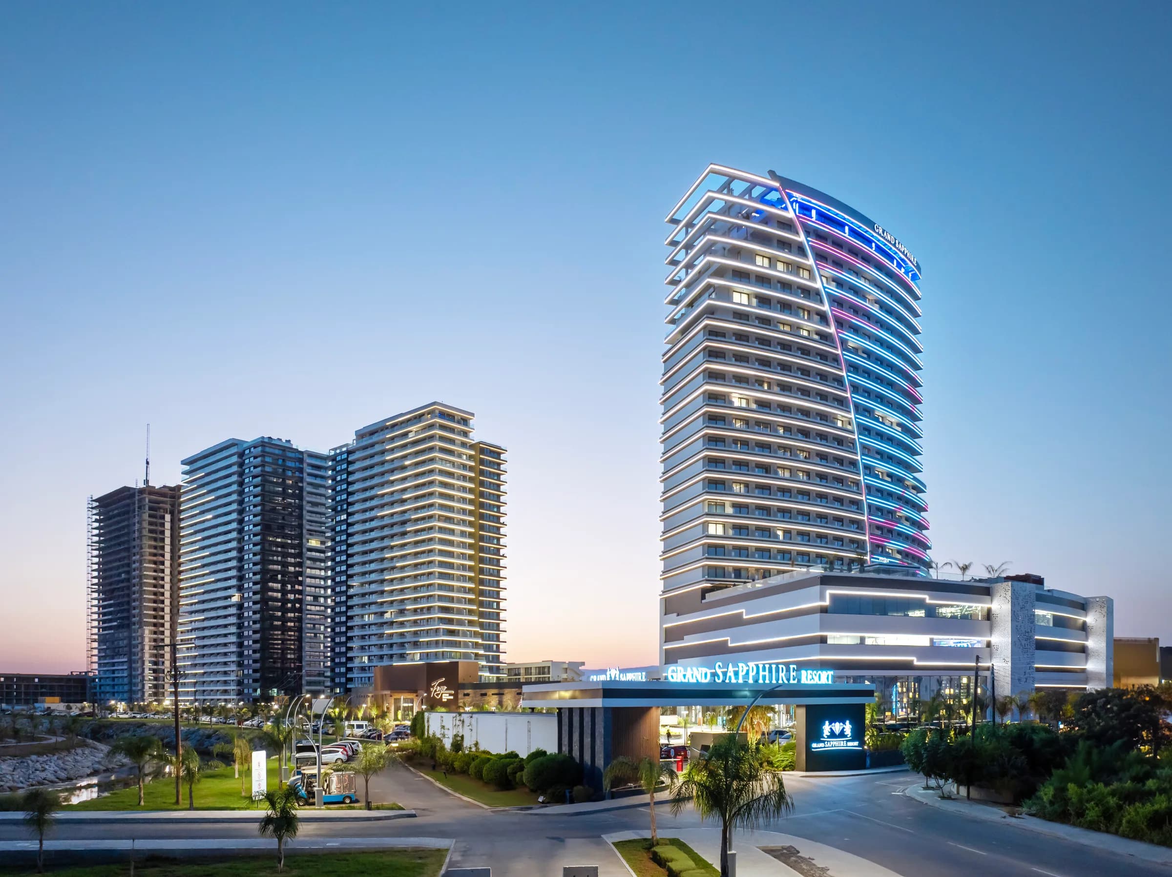 Aerial view of the complex at dusk, with the hotel at the entrance