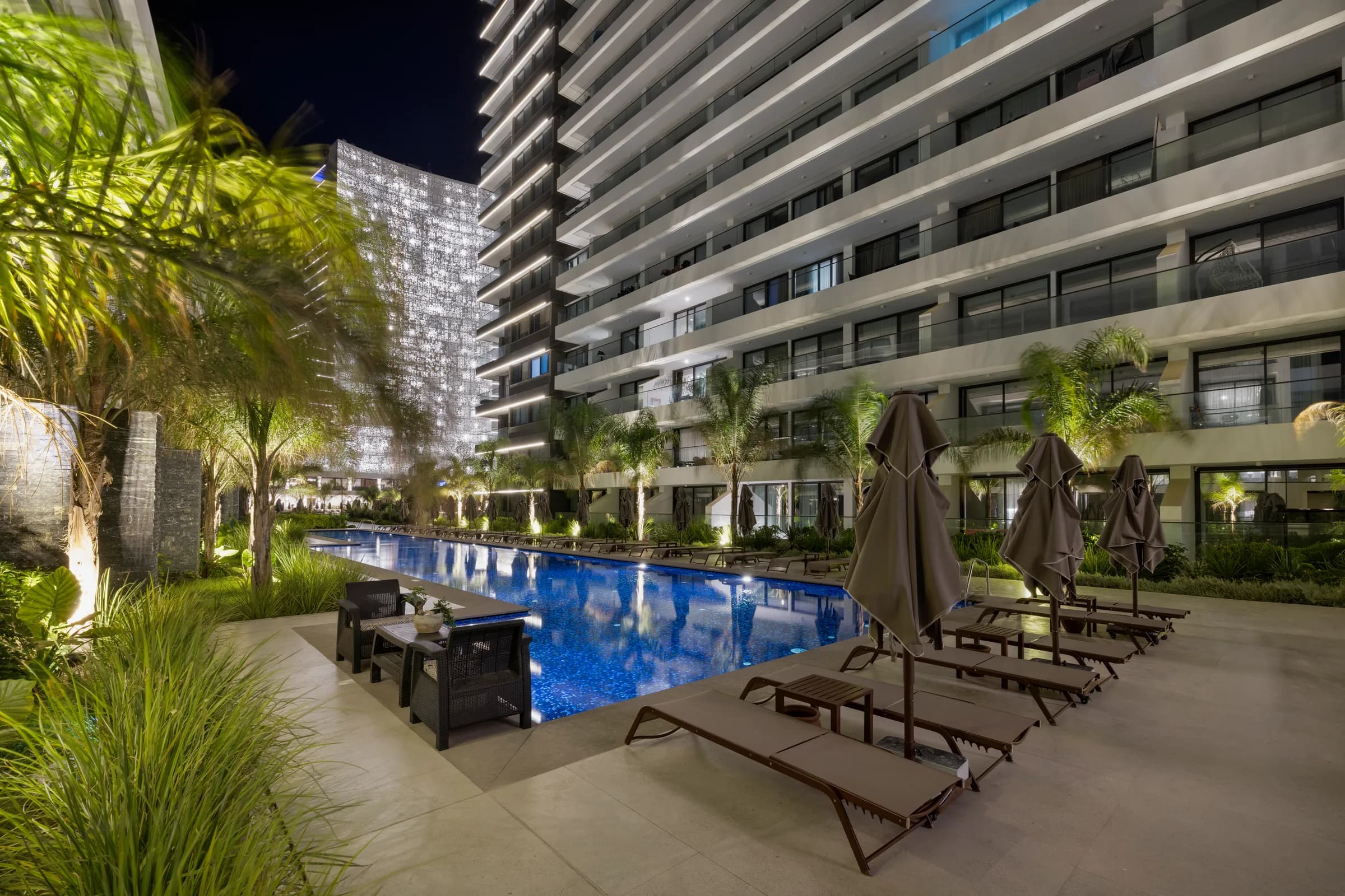 Pool area by a low-rise block at night
